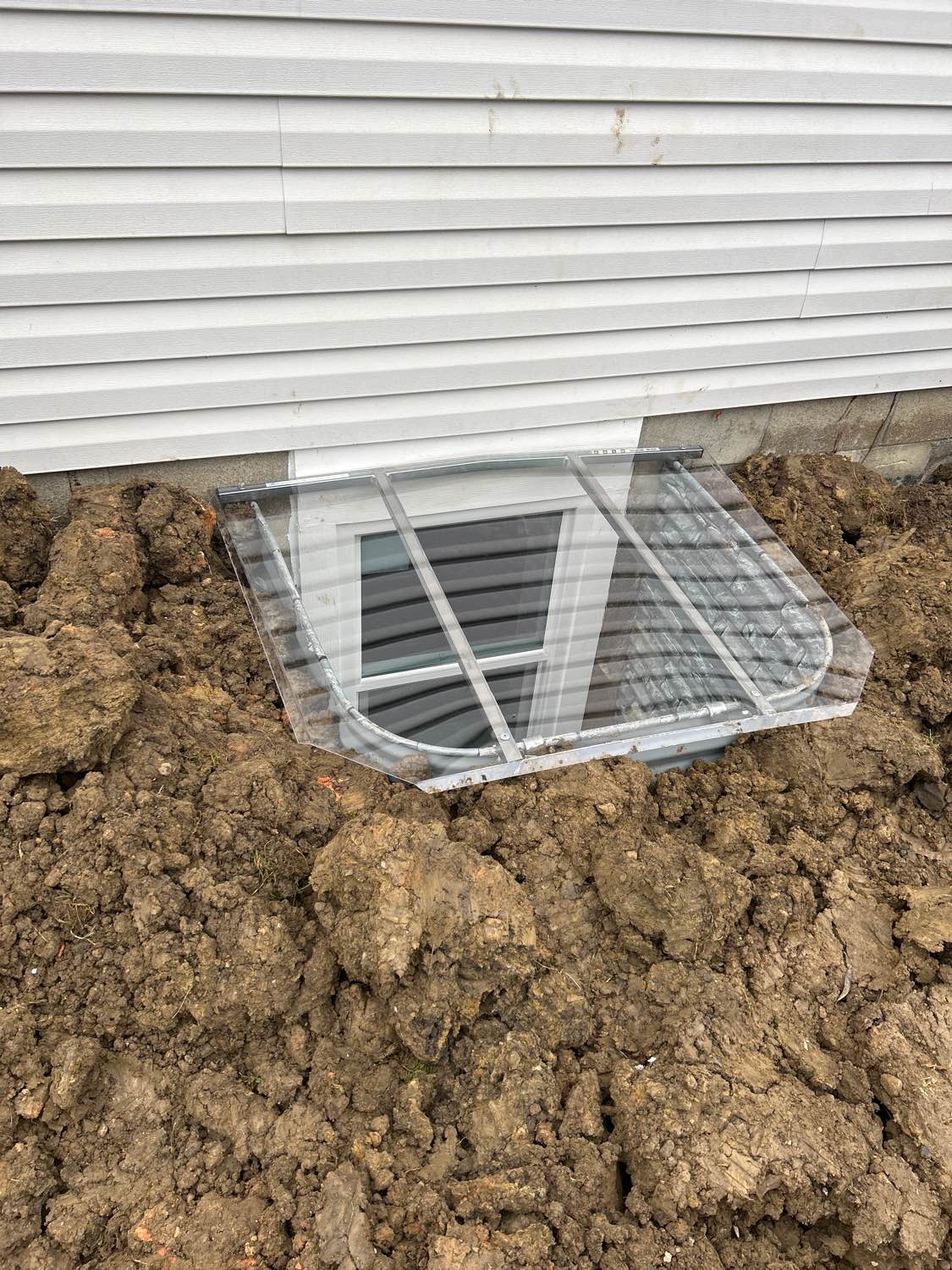 Basement window well with drainage system installed