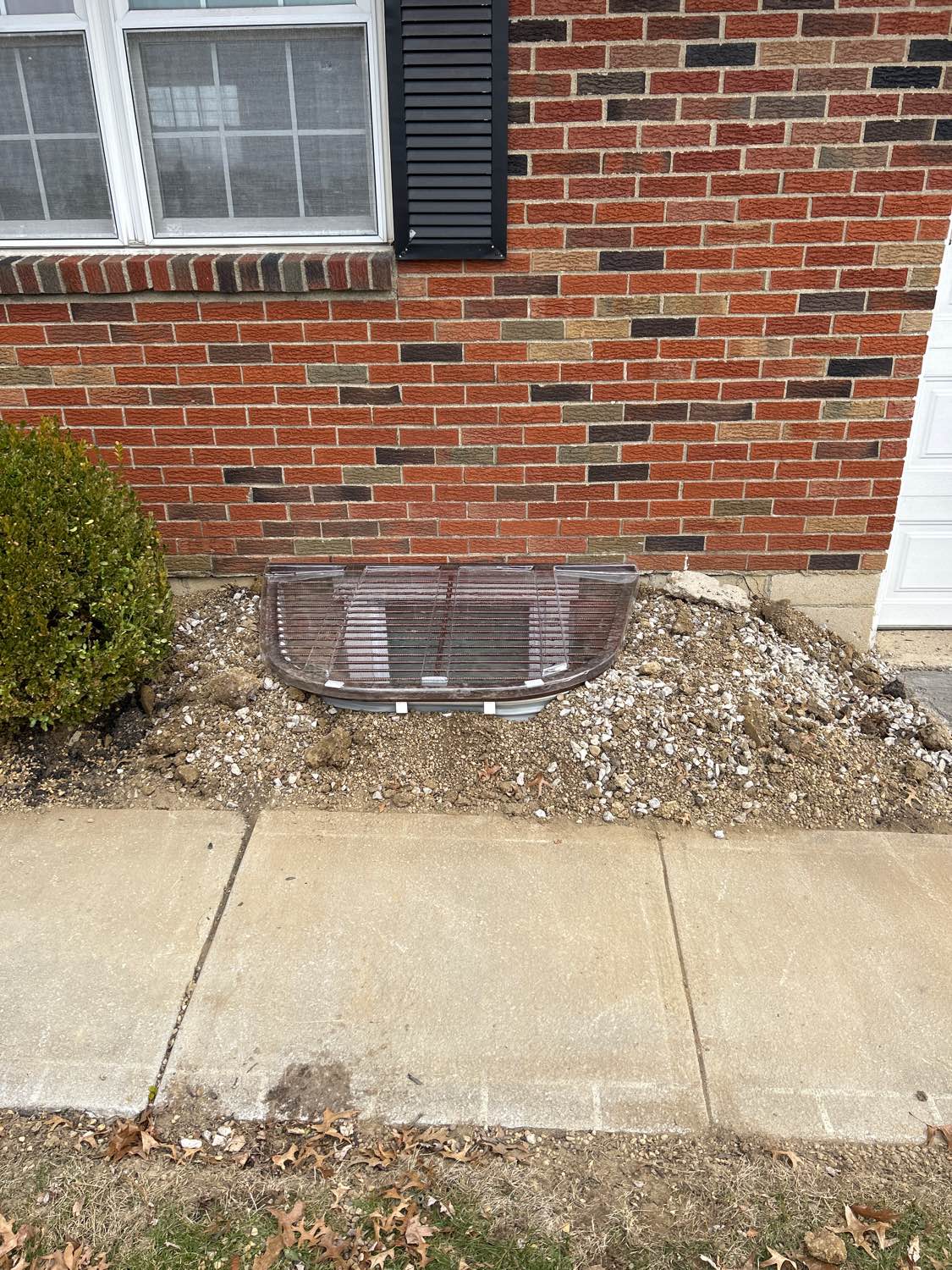 Completed egress and window well — exterior finish
